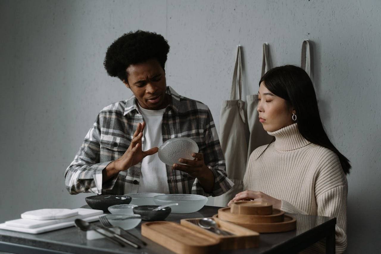 An African American man and Asian woman discussing modern tableware options in a stylish setting.